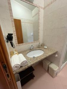uma casa de banho com um lavatório e um espelho em Arra Camere Sirolo - Rooms & Suite em Sirolo