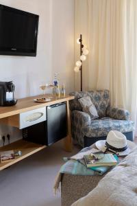 a living room with a television and a couch at Hotel Spa Porto Cristo in Port de la Selva