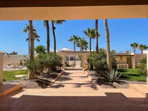 a building with palm trees and a walkway at Corona del Mar By Rocky Host in Puerto Peñasco