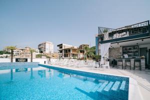 a swimming pool with chairs and a table on a building at Padam Hotel & SPA in Ulcinj