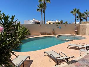 a swimming pool with lounge chairs and a house at Corona del Mar By Rocky Host in Puerto Peñasco