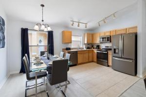 a kitchen with a table and a stainless steel refrigerator at Villa Del Sol in Davenport