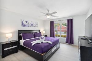a bedroom with a purple bed with a white ribbon on it at Villa Del Sol in Davenport +21 photos