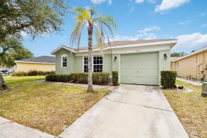 a palm tree in front of a house with a garage at Villa Del Sol in Davenport
