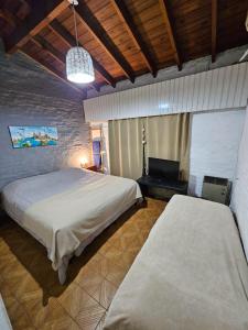 1 dormitorio con 2 camas y TV. en Grace’s House, Ezeiza Airport en Monte Grande