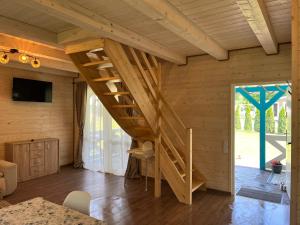 a wooden staircase in a room with a sliding glass door at Domek wakacyjny Wczasy jak Marzenie in Ruciane-Nida