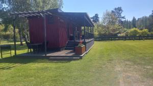 een rode hut met een terras in een veld bij Pids randõ in Kolka