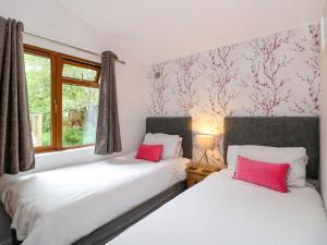 two beds sitting next to each other in a bedroom at Footprints Lodge in Windermere
