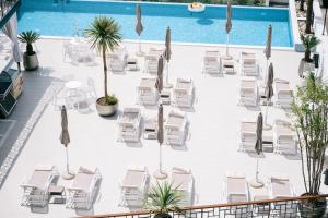 einen Pool mit Stühlen, einem Tisch und einem Pool in der Unterkunft Padam Hotel & SPA in Ulcinj