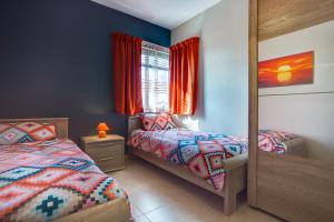 a bedroom with two twin beds and a mirror at Cozy Apartment in St Paul's Bay in St Paul's Bay