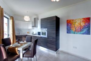 a kitchen with a table and a painting on the wall at Cozy Apartment in St Paul's Bay in St Paul's Bay +2 photos