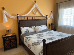 a bedroom with a large bed with a canopy at Corona del Mar By Rocky Host in Puerto Peñasco