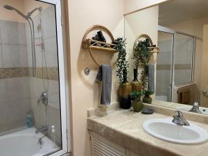 a bathroom with a sink and a shower and a mirror at Corona del Mar By Rocky Host in Puerto Peñasco +26 photos