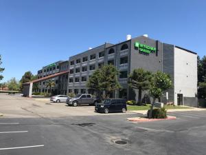 ein großes Gebäude mit Autos auf einem Parkplatz in der Unterkunft Wyndham Garden Newark Fremont Silicon Valley in Newark