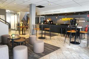 a restaurant with stools and tables and a bar at Comfort Hotel Jönköping in Jönköping