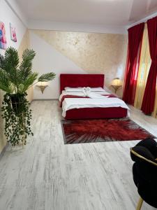 Un dormitorio con una cama grande con cabecero rojo. en Casa Belle, en Năvodari
