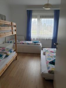 1 Schlafzimmer mit 2 Etagenbetten und einem Fenster in der Unterkunft Apartment Moni in Lutzmannsburg, 1 km von der Sonnentherme entfernt - Apartment mit 3 Schlafzimmern in Lutzmannsburg