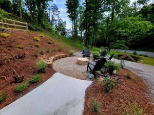 a walkway with a bench and a park with trees at Lil Cabin in the Cove! MTN views, theater, hot tub, games, king beds, Prime Location! in Sevierville +31 photos