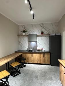 a kitchen with a black refrigerator and wooden counters at Wood hostel Osh in Osh