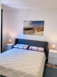 a bedroom with a bed with two lamps and a painting on the wall at Emmi Apartments in Marusici 