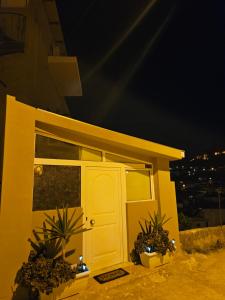una casa amarilla con una puerta y algunas plantas en Με θέα το Κάστρο, en Nafpaktos