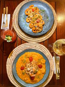 tres platos de comida en una mesa de madera en Kastel Jampa Hotel en João Pessoa