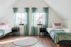 two beds in a room with green curtains at Guestly Homes - Spacious 5BR Villa with Sauna in Södra Sunderbyn