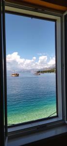 uma janela com vista para o oceano em Beach rooms Riviera - Žuta Kuća em Makarska