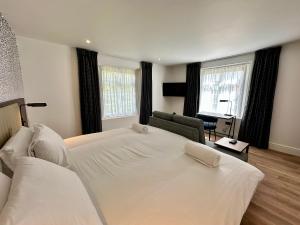 a bedroom with two white beds and a desk at Rhode Lane - Serviced Apartments Bridgwater in Bridgwater