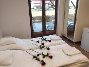 Una cama blanca con flores encima. en Apartamenty przy szlaku, en Krajno Pierwsze