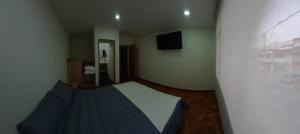a small bedroom with a bed and a television at Casa Palermo Manizales in Manizales