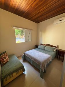 um quarto com 2 camas e uma janela em Casa Canto do Bambu em Delfinópolis