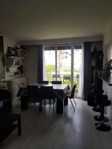 a living room with a table and chairs and a window at Appartement près du lac d'Enghien les bains in Enghien-les-Bains
