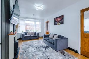 a living room with two couches and a tv at Charming 3BR House near Manchester City Centre with Fast Internet in Manchester