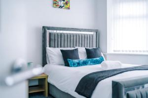 a bedroom with a large bed with blue and white pillows at Charming 3BR House near Manchester City Centre with Fast Internet in Manchester