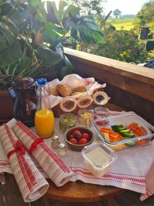 a picnic table with a tray of food and orange juice at Gemütlicher Schäferwagen im Grünen-Schäferwagen 44 in Frielendorf +2 photos