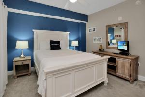 a bedroom with a white bed and a blue wall at Paradise Shores 310 by Pristine Properties Vacation Rentals in Mexico Beach