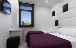 1 dormitorio con 2 camas y ventana en Hoteles Urbanos N Avenida de España, en Fuenlabrada