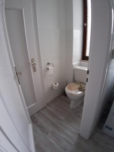 a white bathroom with a toilet and a window at Ferienwohnung Albstadt Panorama in Albstadt +18 photos