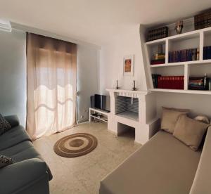 a living room with a couch and a book shelf at Encantadora casa en el corazón de Estepona in Estepona
