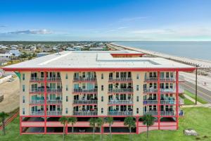 um edifício de apartamentos com palmeiras em frente ao oceano em Paradise Shores 310 by Pristine Properties Vacation Rentals em Mexico Beach