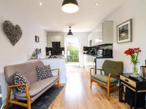 a living room with a couch and chairs and a kitchen at The Den, Bank Top Farm in Ashbourne