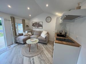 a living room with a couch and a table at Equi-Lodge Jacuzzi au coeur des chevaux & de la nature proche Disney in La Houssaye-en-Brie