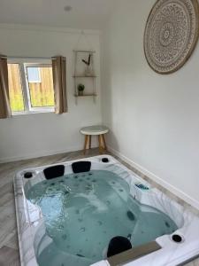 a jacuzzi tub in a room with a window at Equi-Lodge Jacuzzi au coeur des chevaux & de la nature proche Disney in La Houssaye-en-Brie +3 photos