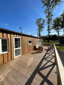 a wooden deck with benches and a house at Equi-Lodge Jacuzzi au coeur des chevaux & de la nature proche Disney in La Houssaye-en-Brie