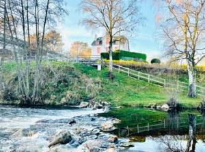 ein Haus auf einem Hügel neben einem Fluss in der Unterkunft Lavignegîte in Bugeat