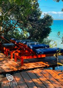 un grupo de sillas azules sentadas en una mesa cerca del océano en 7 CIELOS BACALAR. en Bacalar