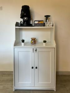 a white cabinet with plants on top of it at Relax House - vicino al centro, lontano dal caos in Casalnuovo di Napoli