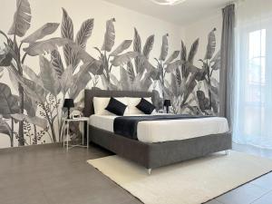 ein Schlafzimmer mit einem großen Bett und einer tropischen Tapete in der Unterkunft Villa Laura Relais in Bologna