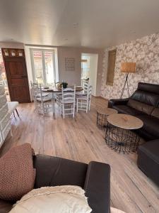 a living room with a couch and a table at Le Cottage d'Emmy - Rose in Commes